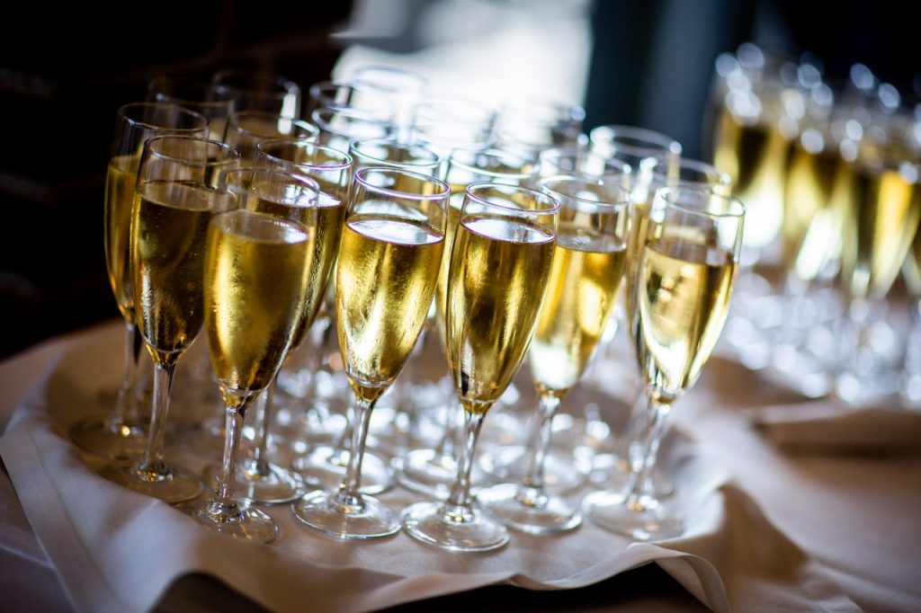 Multiple champagne glasses filled with sparkling wine at an event. Perfect for celebrations and parties.