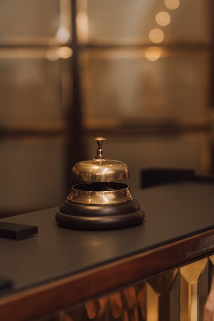 Close-up of a shiny golden bell on a hotel reception desk, exuding luxury and elegance.