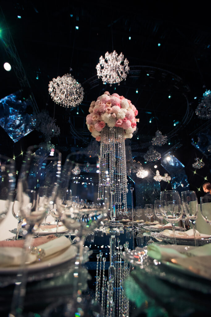 tall centrepiece made of pink flowers and crystal chains stands
